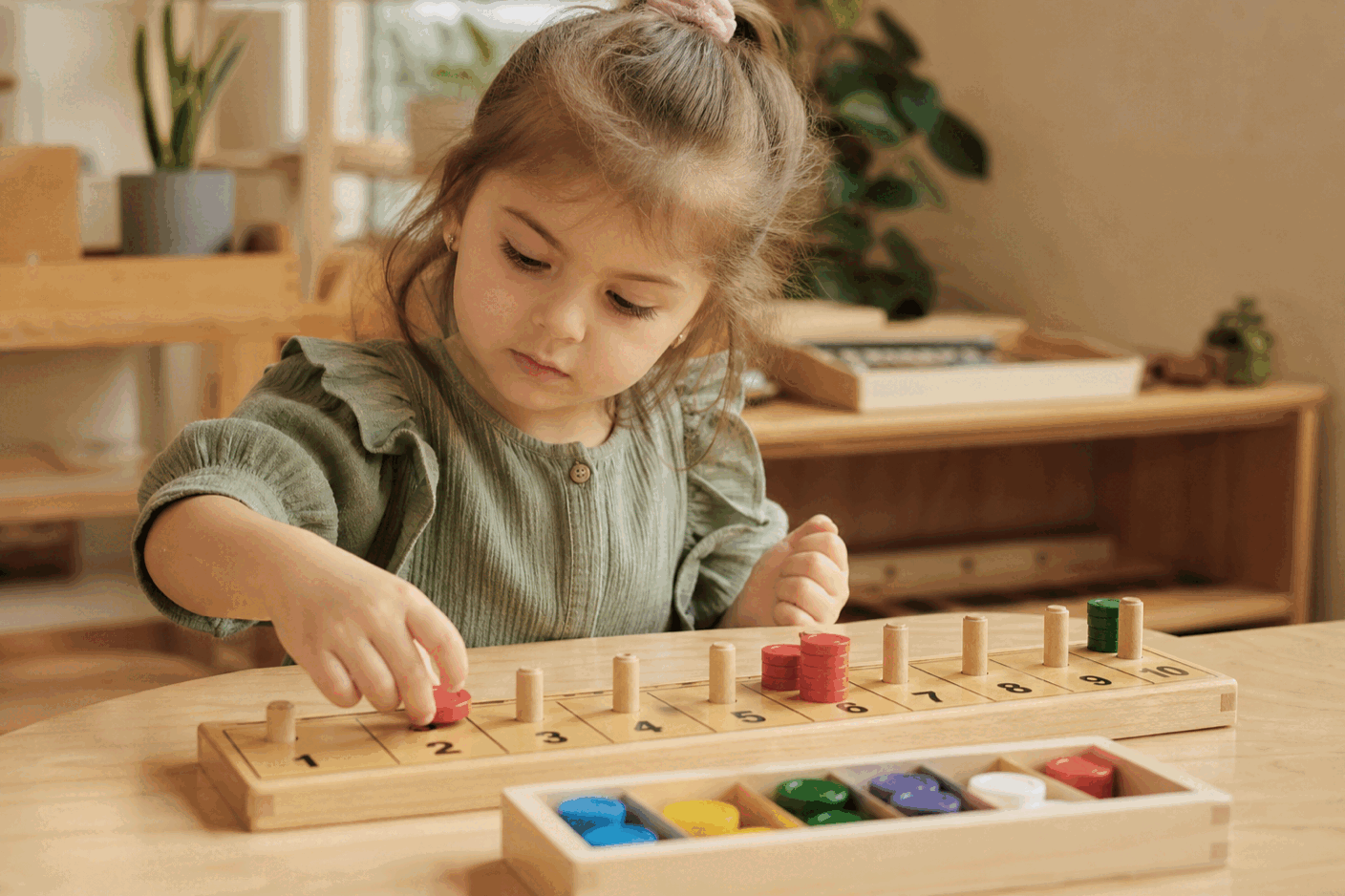 Girl handling concrete Montessori materials